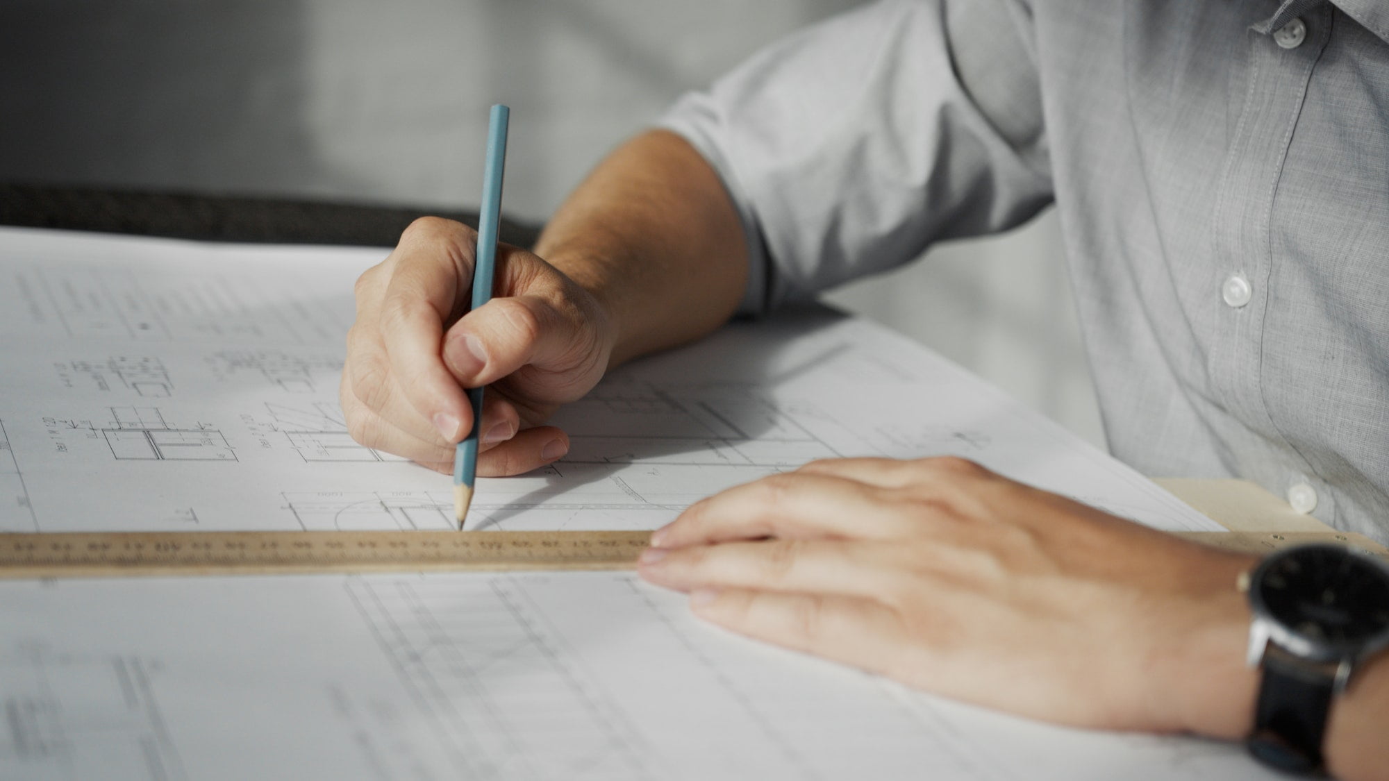 Engineer's hands drawing a construction plan